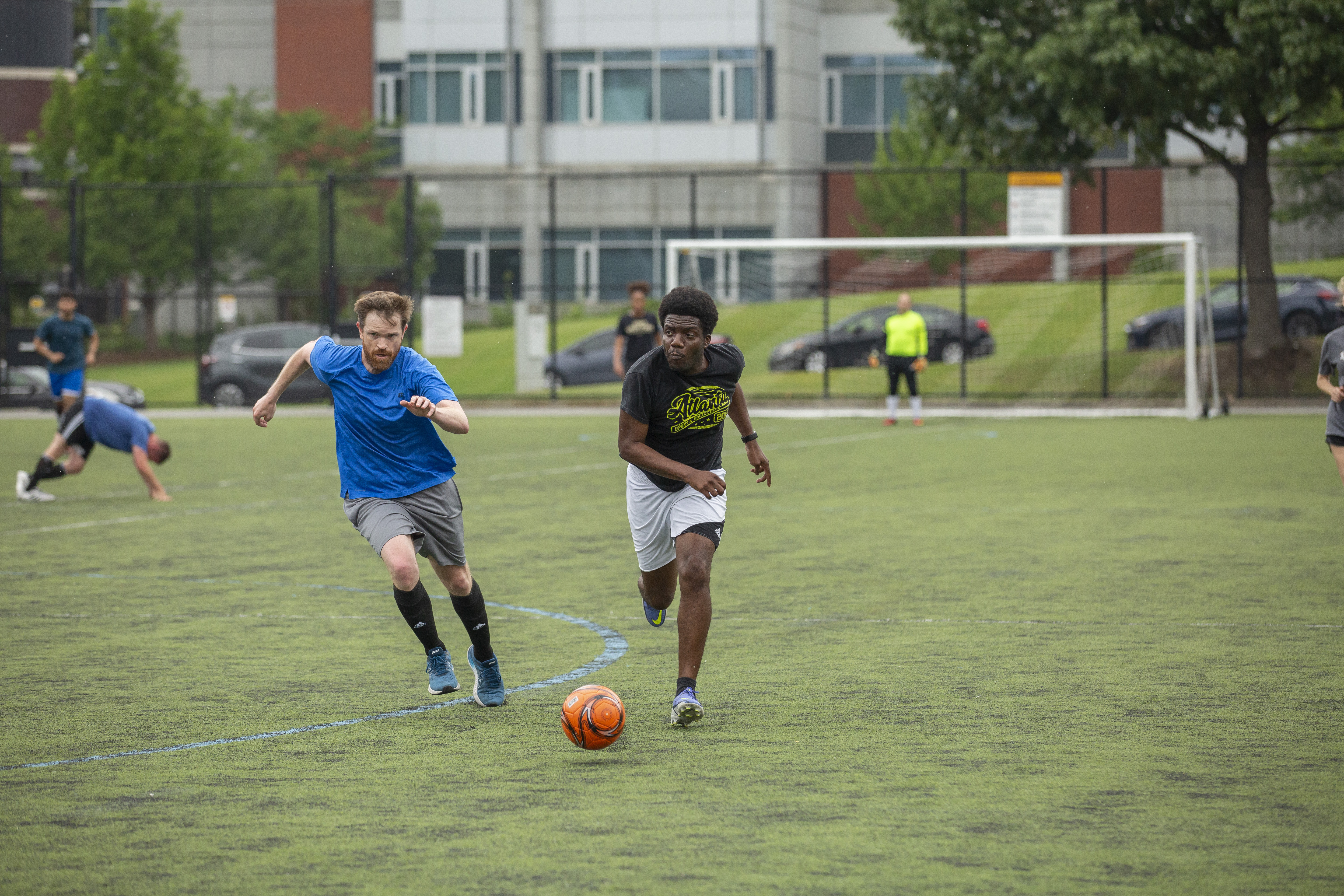 Two GTRI employees run down the soccer field, trying to score a goal. (Photo Credit: Christopher Moore)