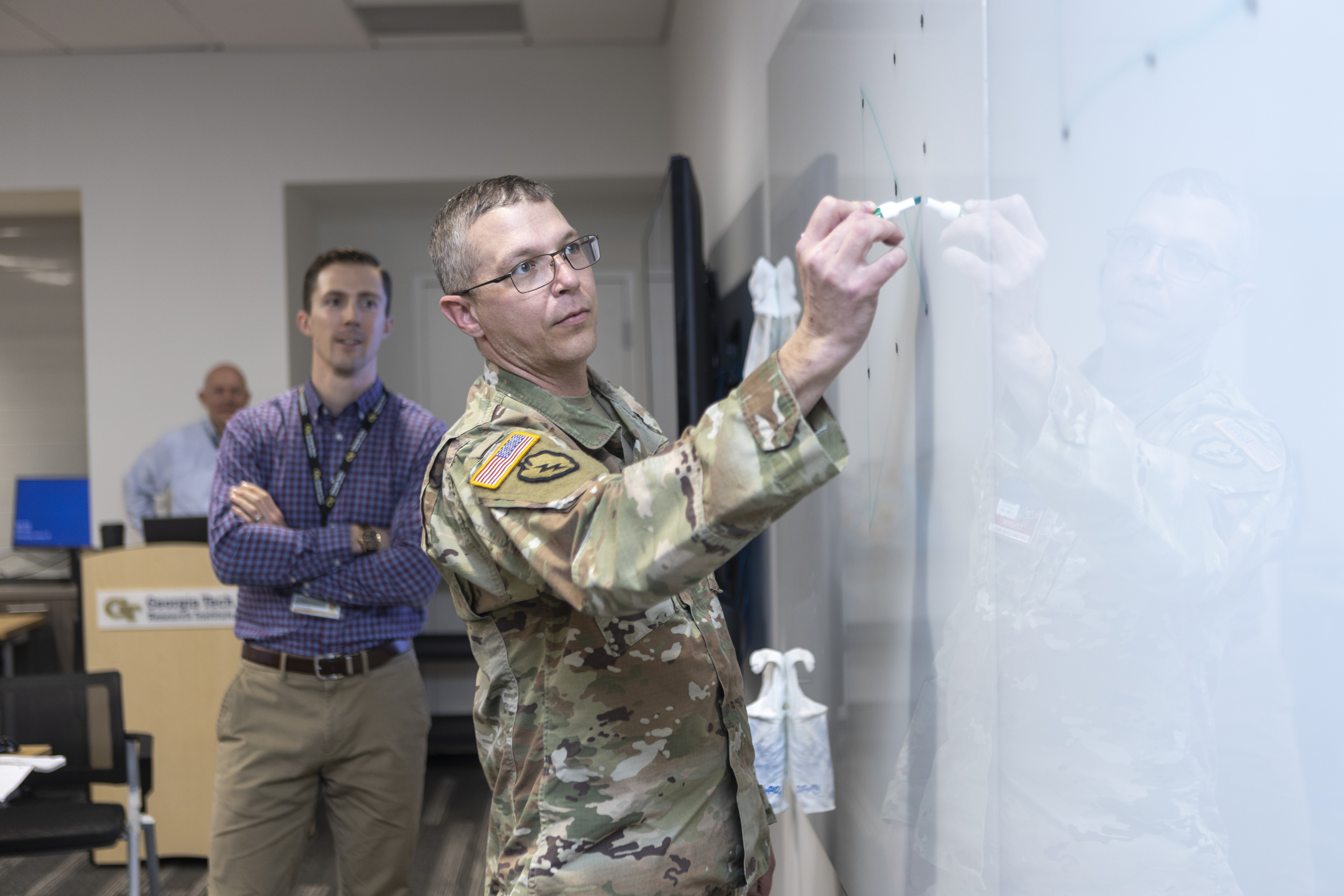 Participants of the Georgia Army Nation Guard working group brainstorm ideas on the whiteboard. (Credit: Christopher Moore)