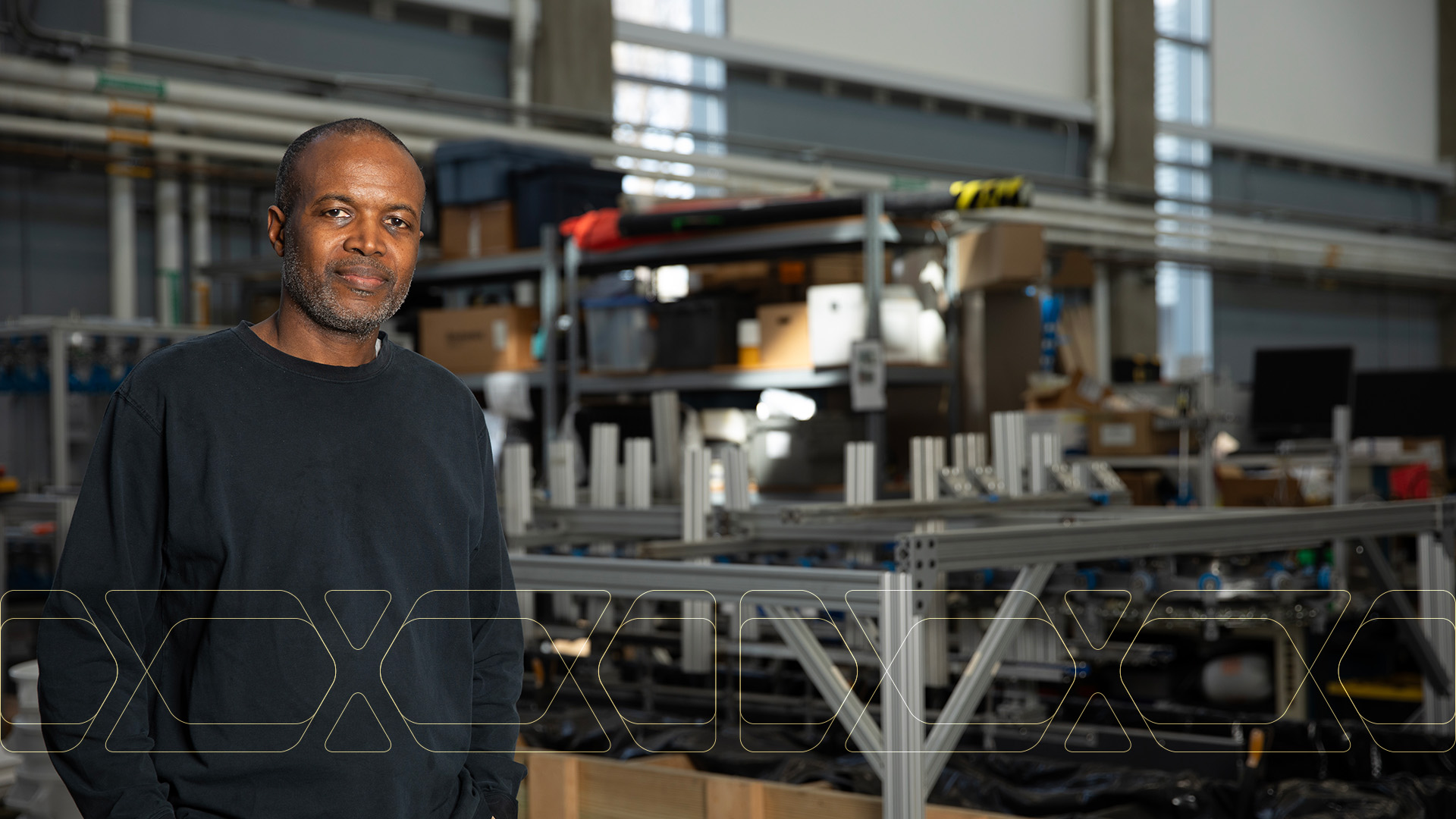 Comas Haynes standing inside  a research facility with equipment in background.