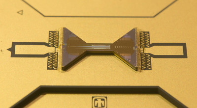 Extreme closeup view of gold scientific device that looks like a bow tie.