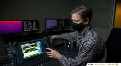 Researcher sitting while making adjustments to electronic equipment 